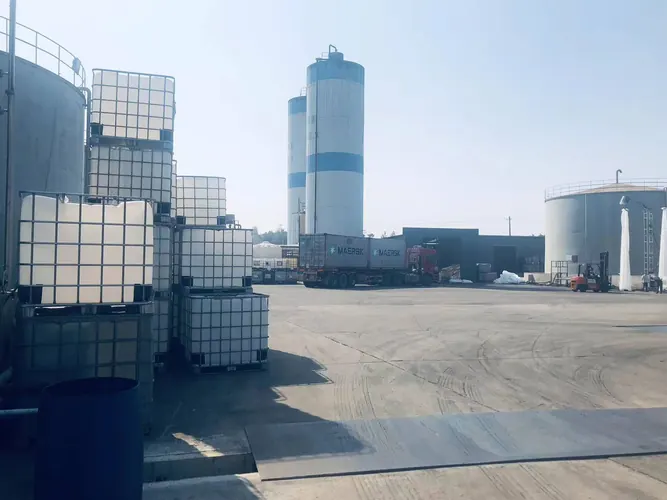 Chemical plant loading area with IBC containers and bulk storage tanks for diethanolamine supply